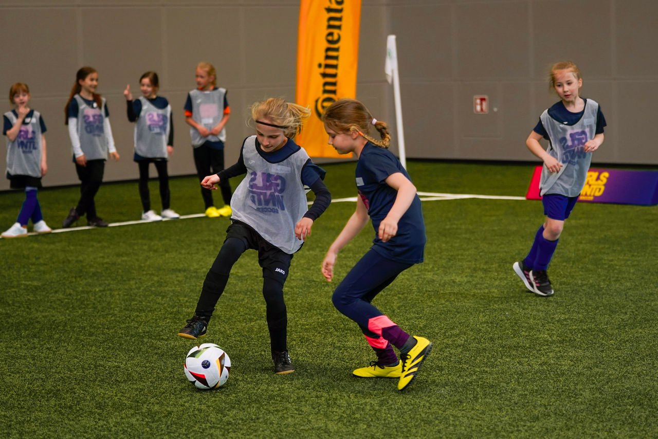 Mädchen spielen Fußball, im Hintergrund sind Continental Banner zu sehen