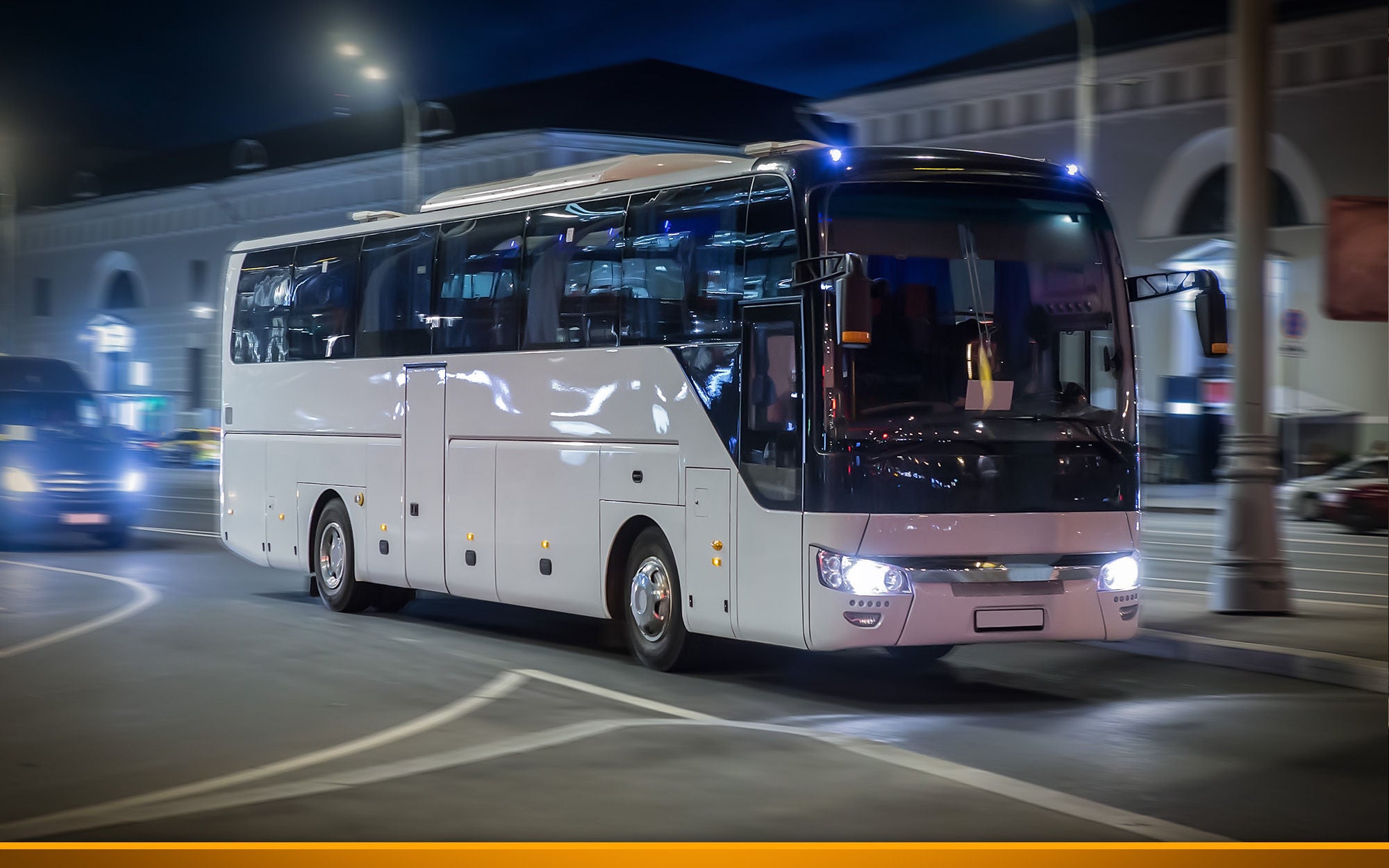 Tourist bus moves at night on a city street