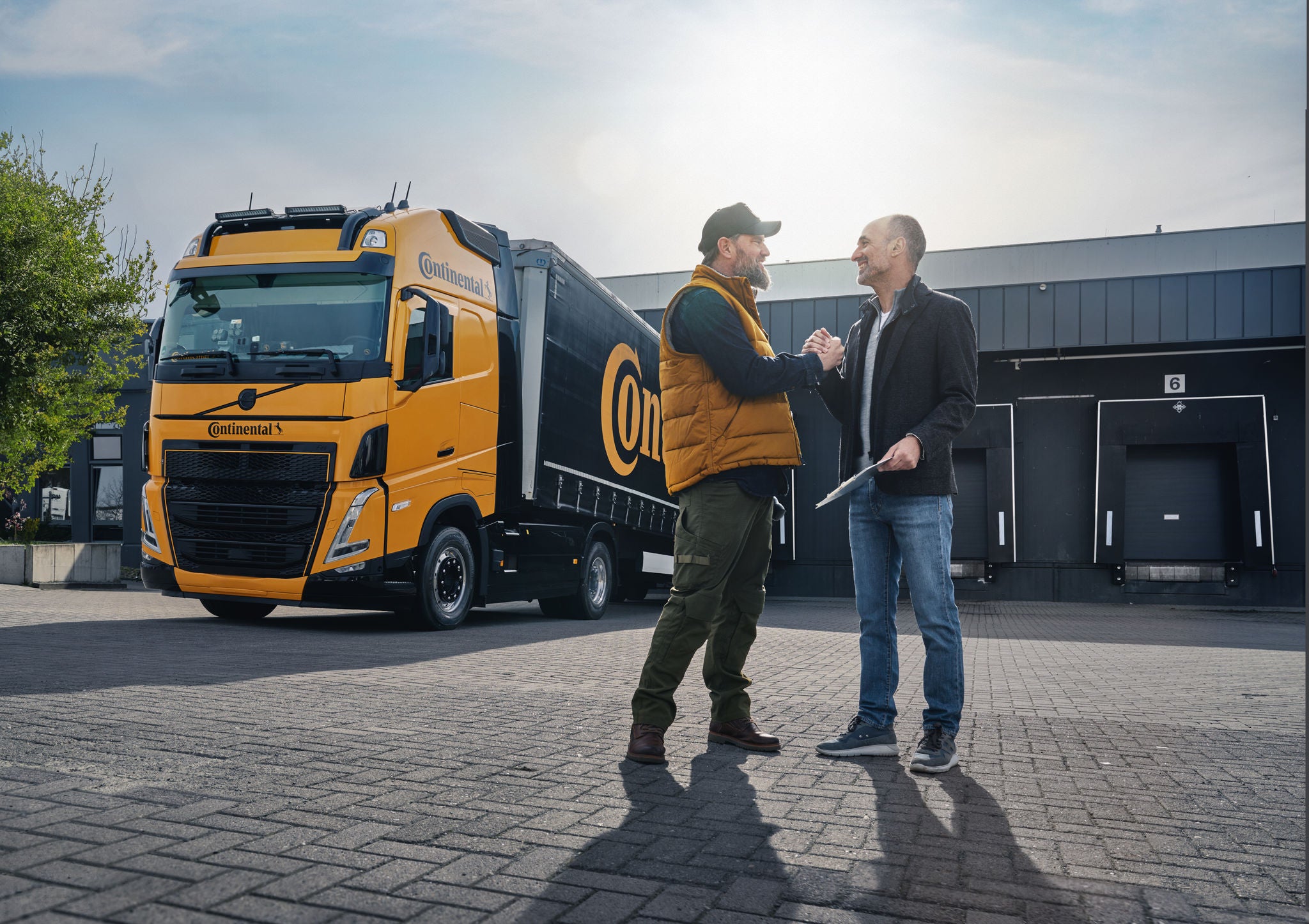 Lkw-Fahrer und Logistiker außerhalb eines Lagers.